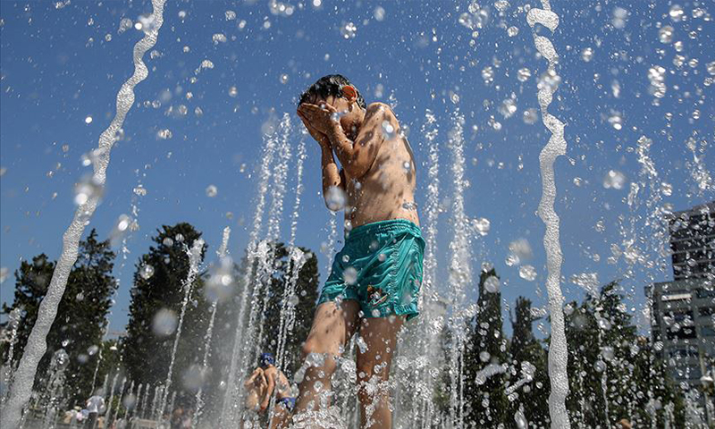 طفل يلعب بالماء مع شدة الحرارة